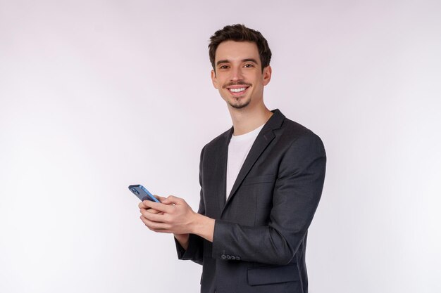Portret van een gelukkige zakenman die smartphone op witte achtergrond gebruikt