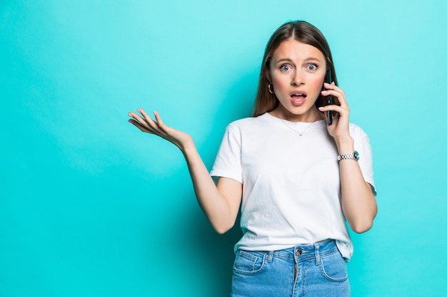 Portret van een geschokte jonge geïsoleerde mobiele telefoon van de meisjesbespreking