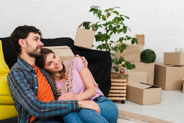 Gratis foto portret van een glimlachend jong paar dat in hun nieuwe flat ontspant