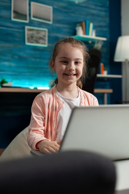 Portret van een glimlachend schoolkind dat in de camera kijkt terwijl hij literatuur studeert