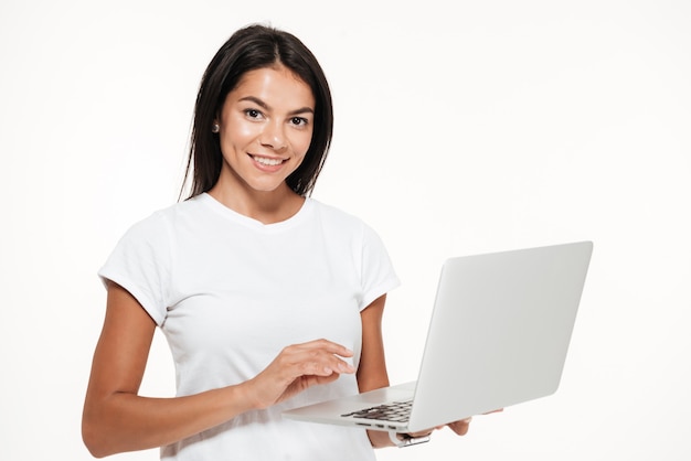 Portret van een glimlachende donkerbruine laptop van de vrouwenholding computer