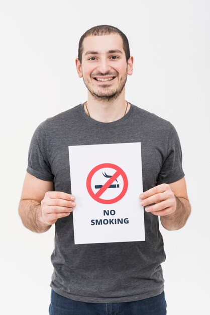 Portret van een glimlachende jonge mens die geen rokend teken toont dat op witte achtergrond wordt geïsoleerd