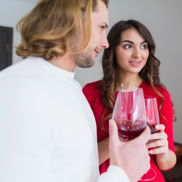 Portret van een glimlachende jonge paar wijnglazen in de hand te houden