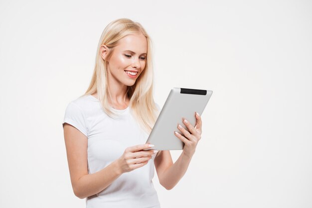 Portret van een glimlachende jonge vrouw die aan tablet werkt