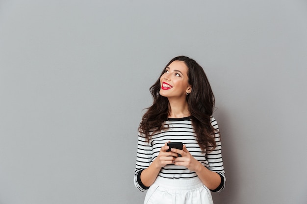 Portret van een glimlachende vrouw die mobiele telefoon houdt