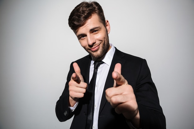 Portret van een glimlachende zelfverzekerde man in pak en stropdas