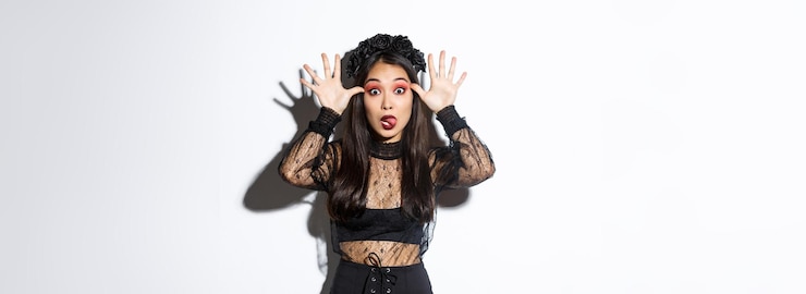 Gratis Foto portret van een grappige en dwaze aziatische vrouw in heksenkostuum die halloween viert die iemand bespot