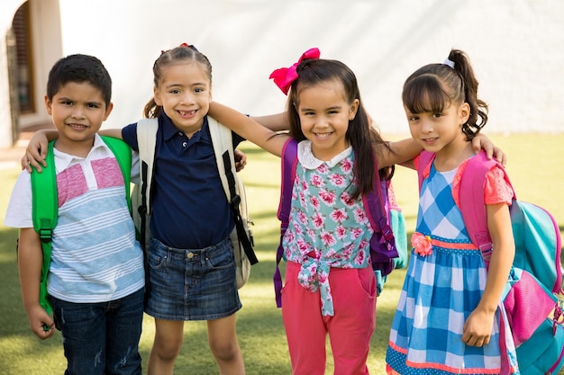 Portret van een groep vrienden die buiten rondhangt terwijl ze samen naar de kleuterschool gaan