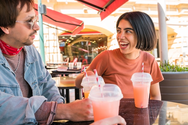 Portret van een groep vrienden die samen plezier hebben en genieten van een goede tijd terwijl ze vers vruchtensap drinken in café