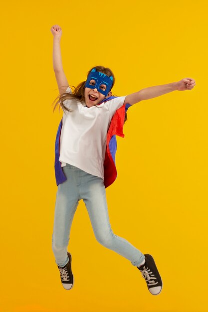 Portret van een jong meisje met een superheldencape