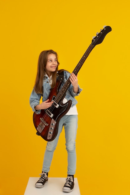 Gratis foto portret van een jong meisje met gitaar