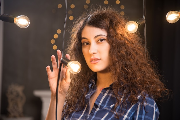 Portret van een jong model in geruit hemd poseren in de buurt van lampen