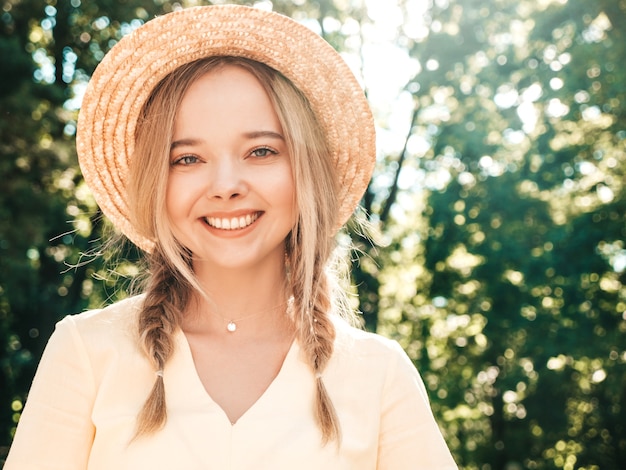 Portret van een jong mooi glimlachend hipstermeisje in trendy zomerjurk