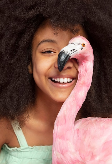 Portret van een jong schattig meisje poseren met speelgoed flamingo