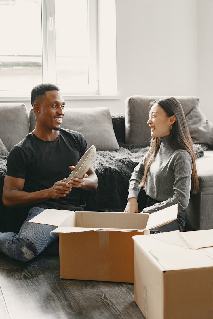 Gratis Foto portret van een jong stel met kartonnen dozen in een nieuw huis, een verhuisconcept