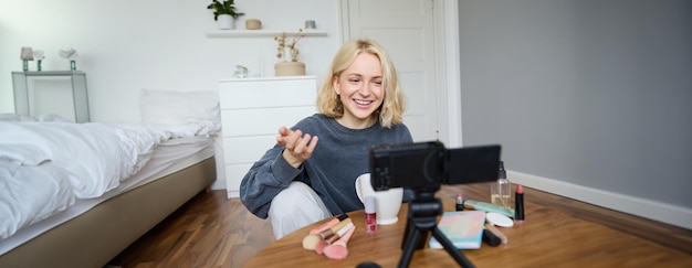 Gratis foto portret van een jong tienermeisje in haar kamer die een vlog van haar dagelijkse levensstijl opneemt voor sociale media