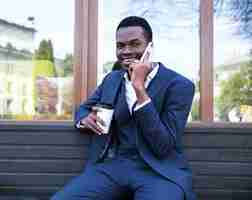 Gratis foto portret van een jonge afrikaanse zakenman die op mobiele telefoon spreekt
