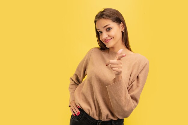 Portret van een jonge blanke vrouw met heldere emoties geïsoleerd op geel