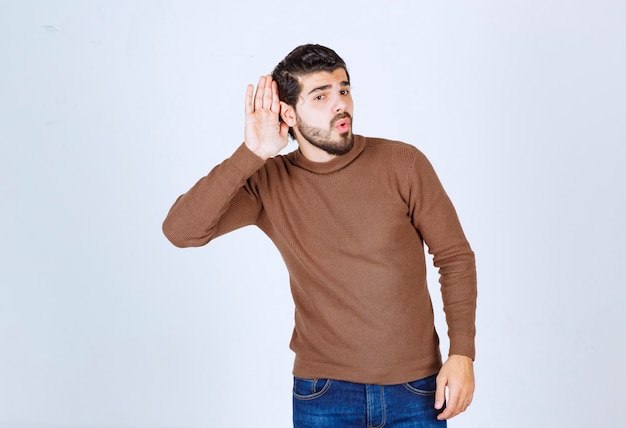 Portret van een jonge casual man die een gesprek hoort