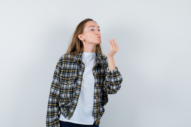 Portret van een jonge dame die luchtkus verzendt met pruilende lippen in t-shirt, jasje en op zoek schattig vooraanzicht