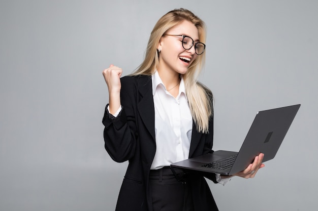 Portret van een jonge gelukkig zakenvrouw met een laptop met winst gebaar