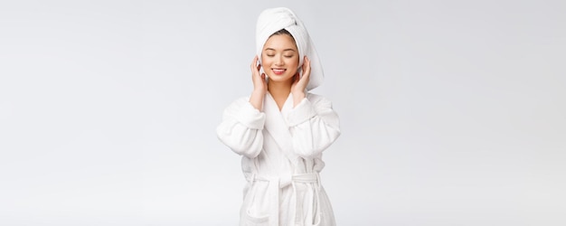 Portret van een jonge gelukkige Aziatische dame in badjas Geïsoleerd op witte achtergrond