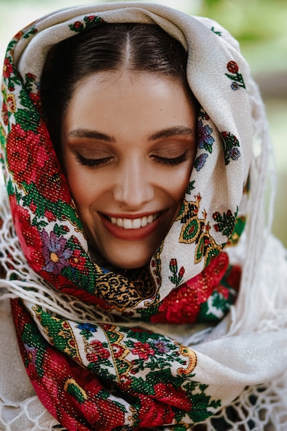 Portret van een jonge glimlachende vrouw in een traditionele geborduurde jurk