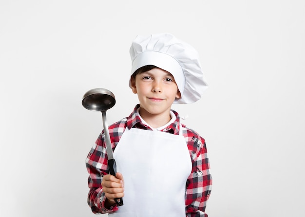 Gratis foto portret van een jonge jongen die zich voordeed als chef-kok