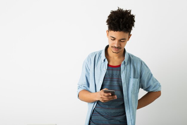 Portret van een jonge knappe zwarte man, met digitaal apparaat, met behulp van smartphone, geïsoleerd op een witte achtergrond, Afro-Amerikaanse jeugd, hipster stijl, student, drukke