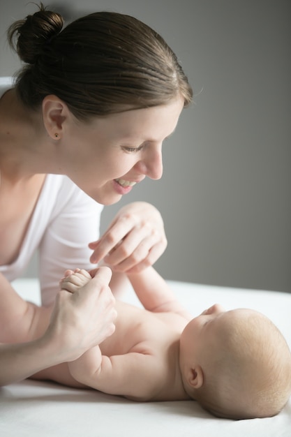 Portret van een jonge lachende vrouw die met anewborn speelt