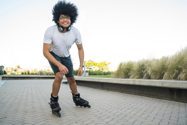 Portret van een jonge Latijns-man die buiten op straat rolschaatst