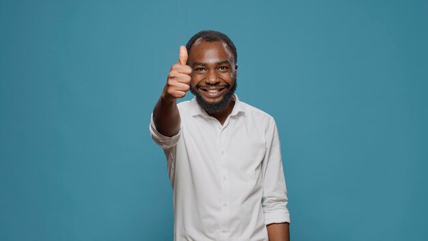 Portret van een jonge man die duimen omhoog en omlaag teken voor de camera toont. Positieve persoon die waardering en goedkeuring geeft, zich dan ontevreden en teleurgesteld voelt en reclame afkeurt.