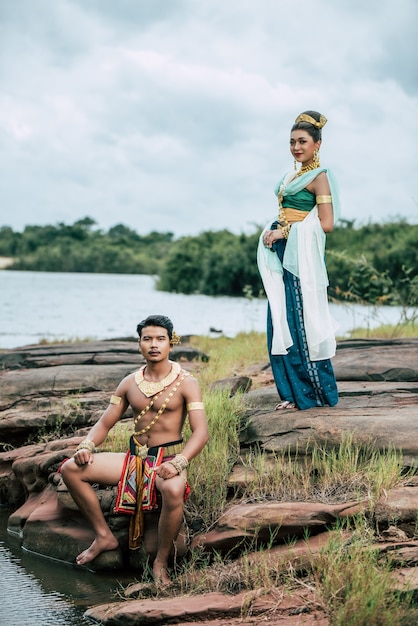 Portret van een jonge man en vrouw met een prachtig traditioneel kostuum poseren in de natuur in Thailand