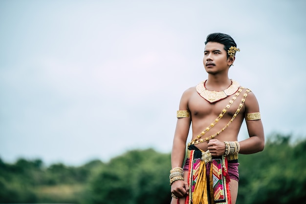 Gratis foto portret van een jonge man in klederdracht poseren in de natuur in thailand