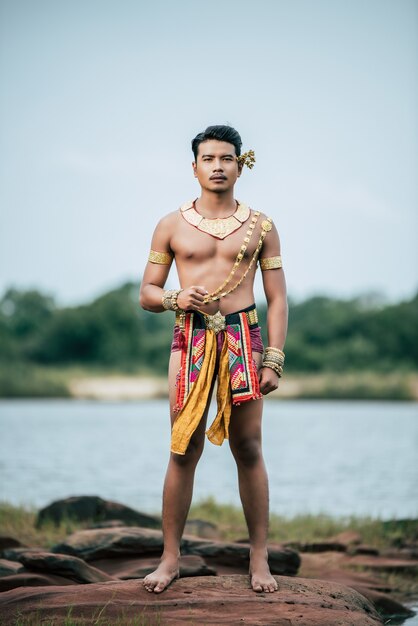 Portret van een jonge man in klederdracht poseren in de natuur in Thailand