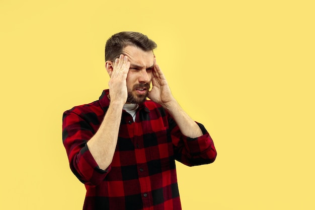 portret van een jonge man in shirt. vooraanzicht. Trendy kleuren. Denken of lijden aan pijn.