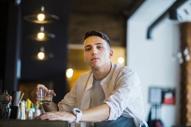 Portret van een jonge man met een glas whisky