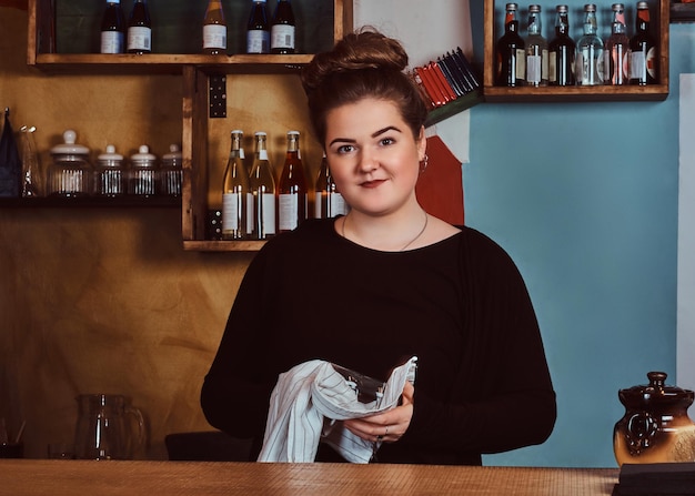 Portret van een jonge, mooie vrouw die naar een camera kijkt terwijl ze achter de toonbank in het filmhuis staat