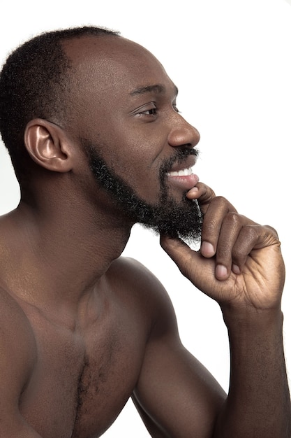 Portret van een jonge naakte gelukkig lachend afrikaanse man in de studio.