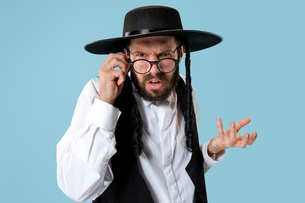 Portret van een jonge orthodoxe joodse man tijdens festival purim. Vakantie, feest, jodendom, religie concept. Menselijke emoties