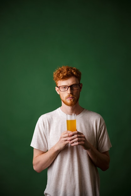 Portret van een jonge roodharige man met glas bier