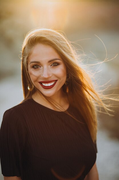 Portret van een jonge sensuele vrouw op een zonsondergang