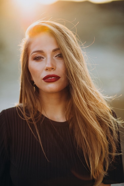 Portret van een jonge sensuele vrouw op een zonsondergang