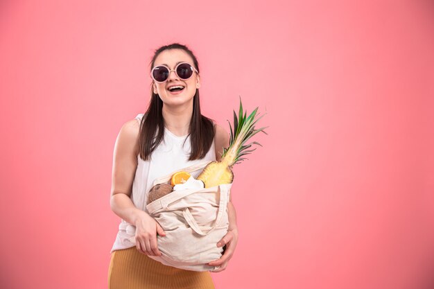 Portret van een jonge stijlvolle vrouw met een eco-fruit tas