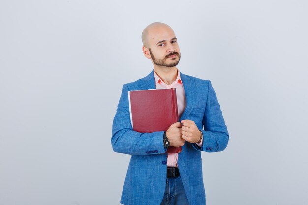 Portret van een jonge vrolijke man die een boek vasthoudt