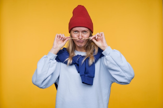 Gratis foto portret van een jonge vrouw die aan het dollen is en een nepsnor laat zien