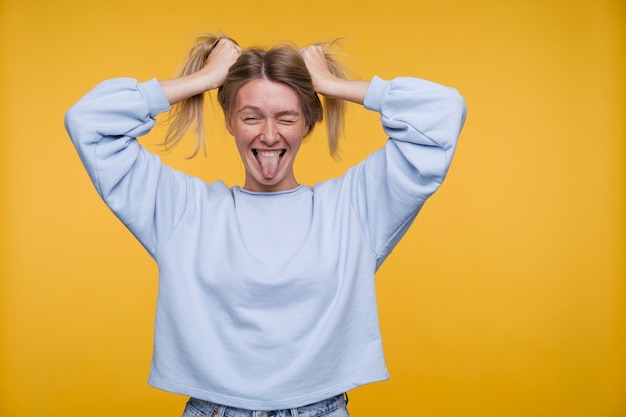 Portret van een jonge vrouw die dom is en haar tong uitsteekt