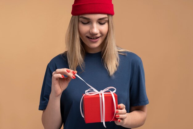 Portret van een jonge vrouw die een cadeau uitpakt