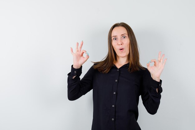 Portret van een jonge vrouw die een goed gebaar toont