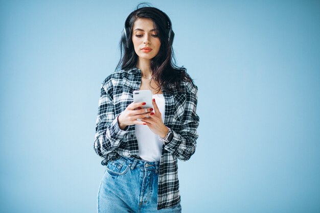 Portret van een jonge vrouw die in oortelefoons aan muziek luistert